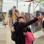 Visitantes tomando una fotografía en una exposición de arte en la Estación Tupahue del Teleférico Santiago.