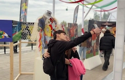 Visitantes tomando una fotografía en una exposición de arte en la Estación Tupahue del Teleférico Santiago.
