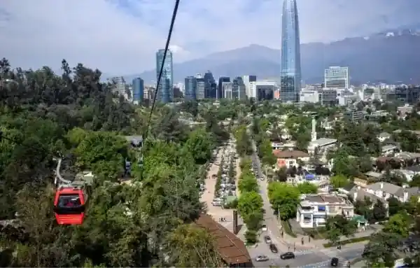 Cabina del Teleférico Santiago sobrevolando el Parque Metropolitano con vista a Santiago y el sector de Oasis