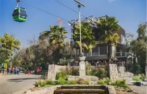 Estación Tupahue del Teleférico Santiago con cabina verde y visitantes en el Parque Metropolitano